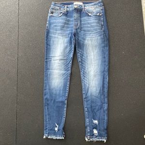 KanCan mid rise medium wash skinny jeans with raw hems.